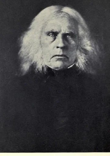 A photographic portrait of Dr. John McLoughlin in later life, in a dark coat, with long white hair.