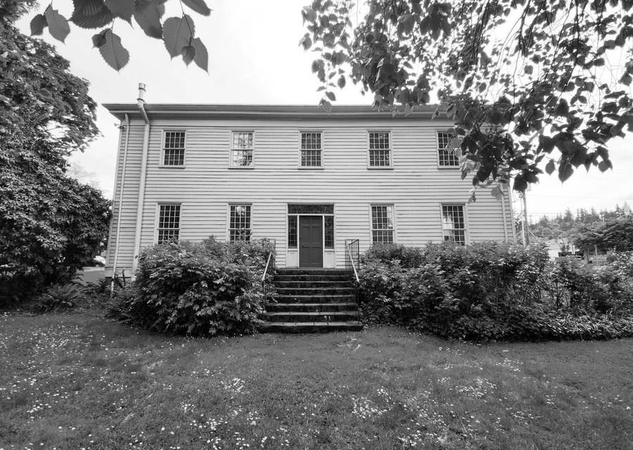 The McLoughlin House, a large white clapboard house with a dark front door at the top of stone steps.